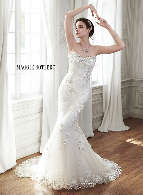 Chante: Refined elegance is found in this fit & flare wedding gown,` constructed of bold three-dimensional lace appliqués and tulle. Complete with floral lace neckline and hemline. Finished with corset closure.