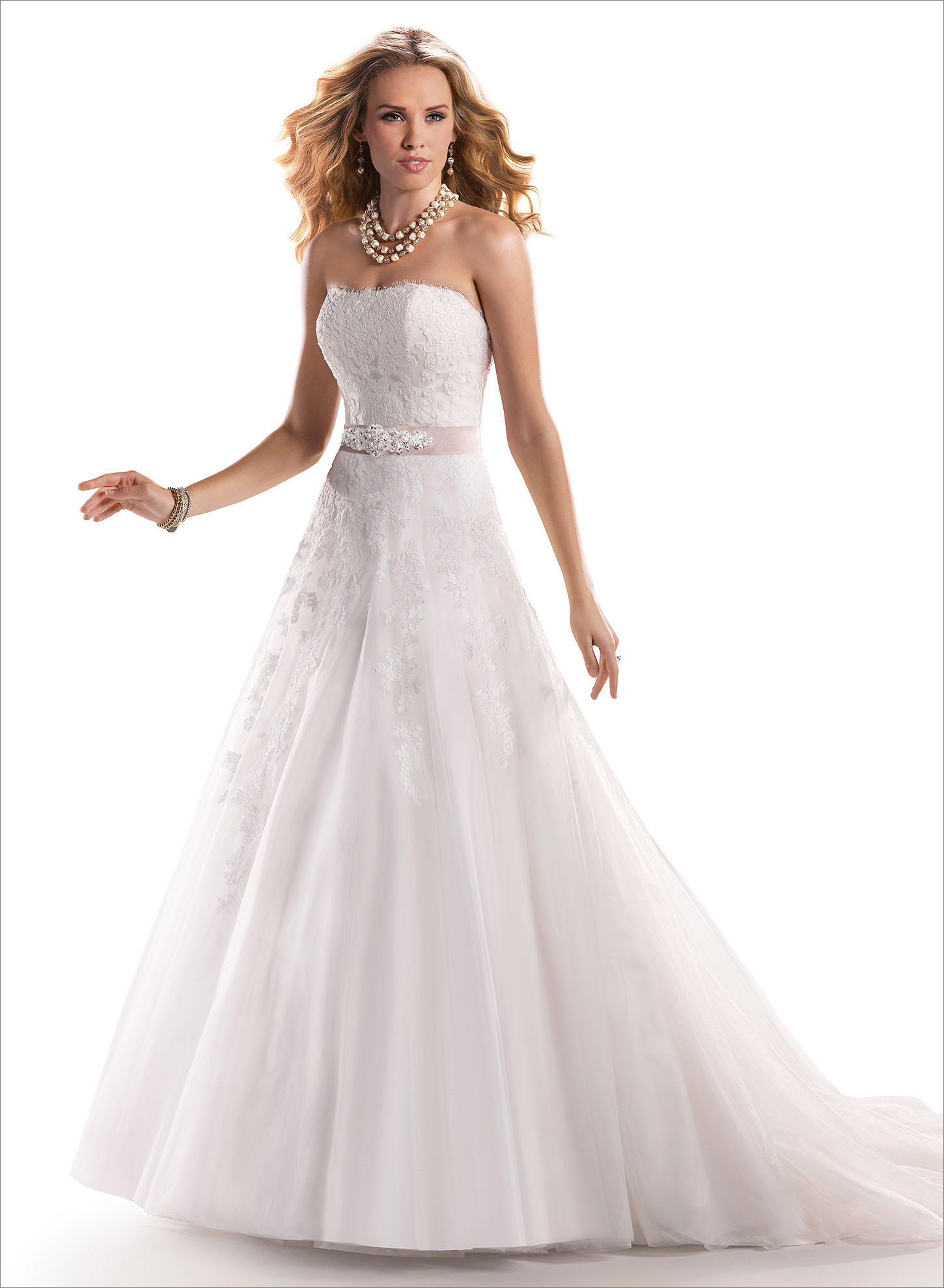 Nadia: The epitome of timeless romance is found in this A-line gown, accented with Alençon lace appliqués floating delicately over a tulle skirt. Finished with strapless scoop neckline and signature corset back closure.